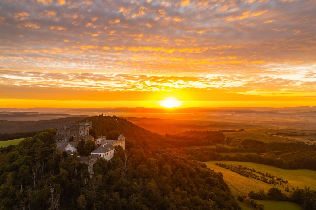Hrad Buchlov - dramatický východ slunce, paprsky procházející skrz mraky