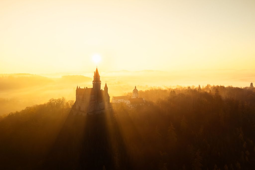 Východ slunce nad hradem Bouzov za mlžného rána